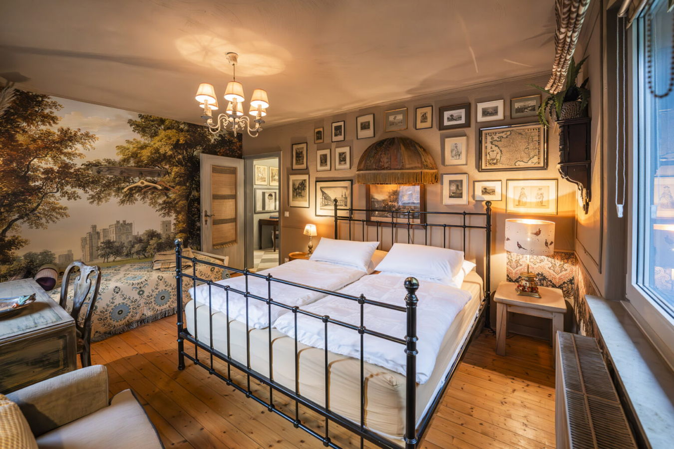 Gemütliches Schlafzimmer mit Doppelbett, Wandbildern und Landschaftstapete