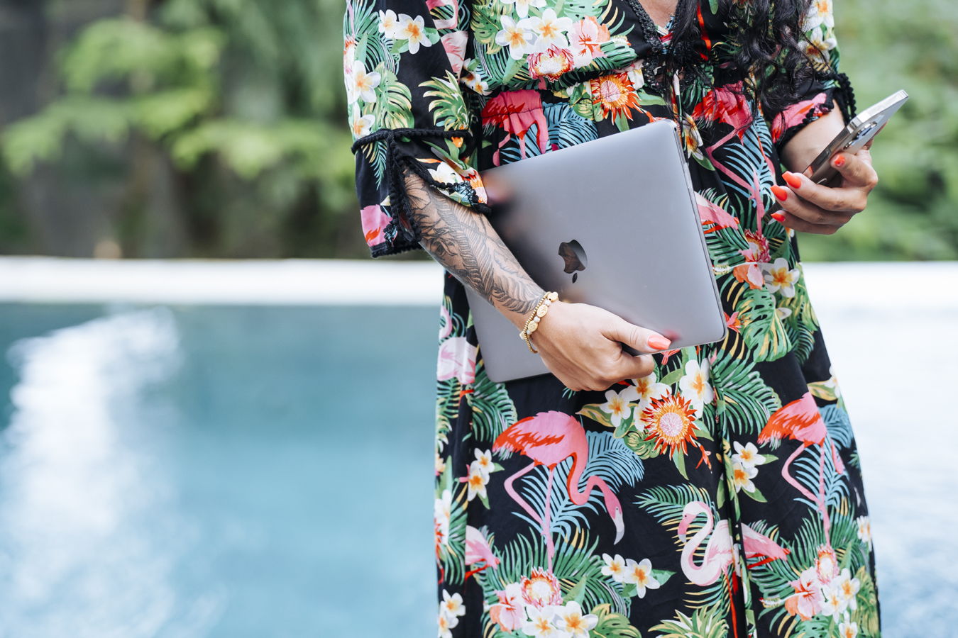 Frau mit Laptop am Pool