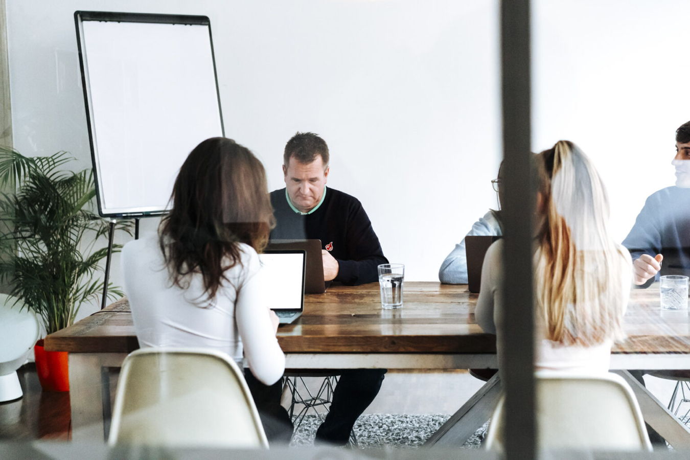 Besprechung mit mehreren Personen an einem Tisch in einem Büro