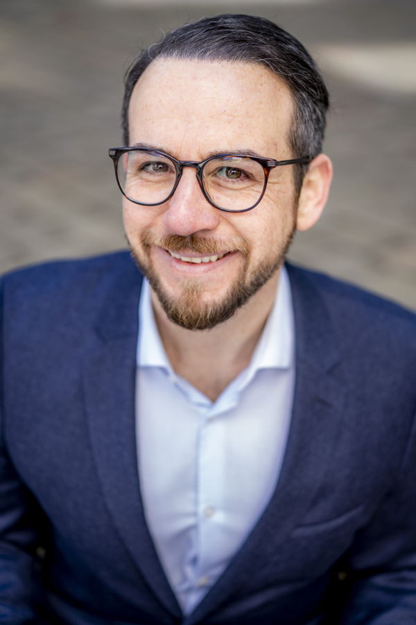 Porträt eines lächelnden Mannes mit Brille im Anzug