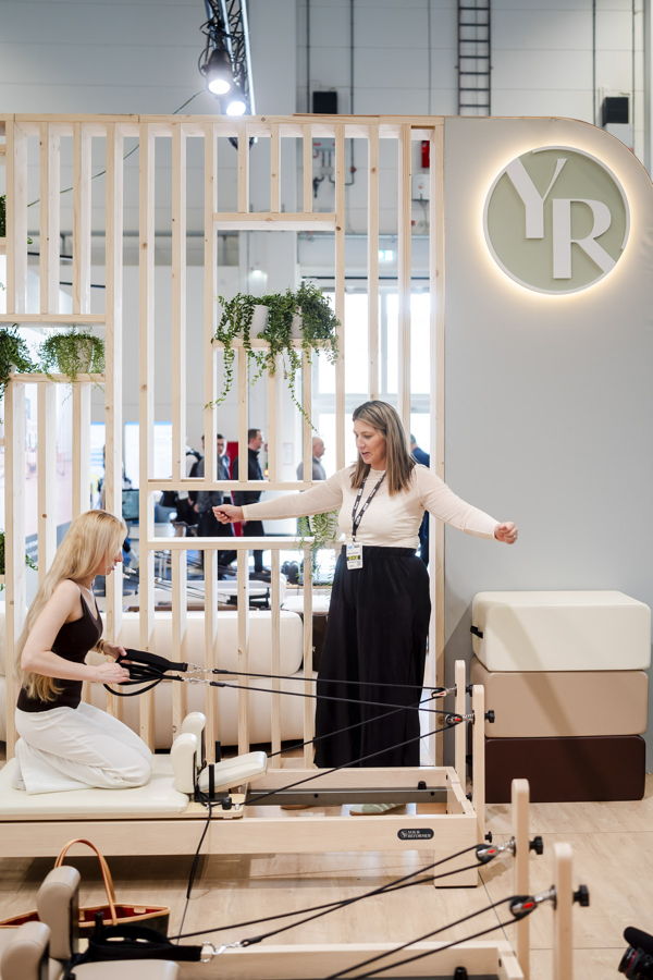 Frauen trainieren an einem Pilates-Reformer auf einer Messe oder in einem Studio