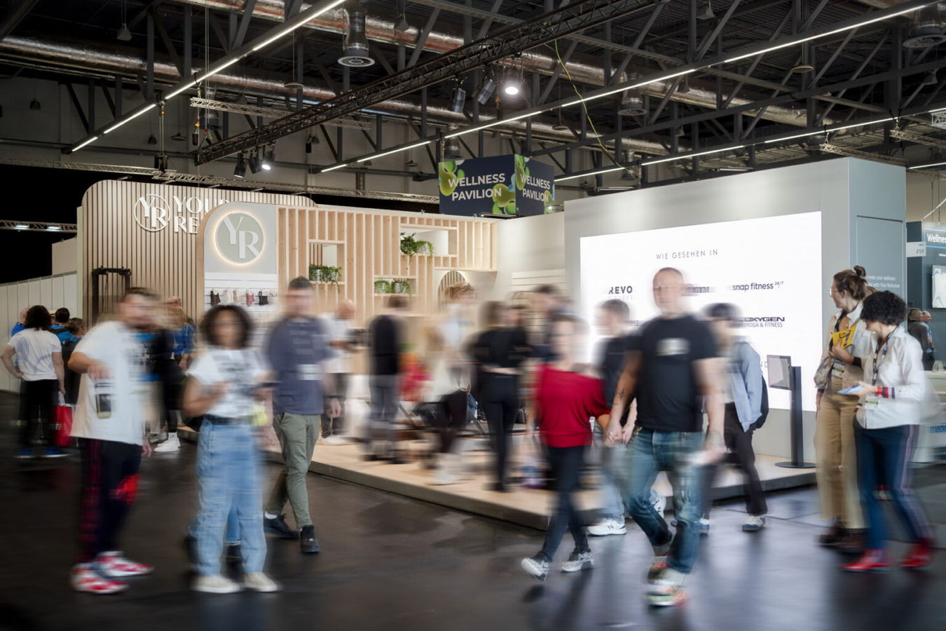 Messestand auf einer Messe mit vielen vorbeigehenden Besuchern im Wellness Pavilion