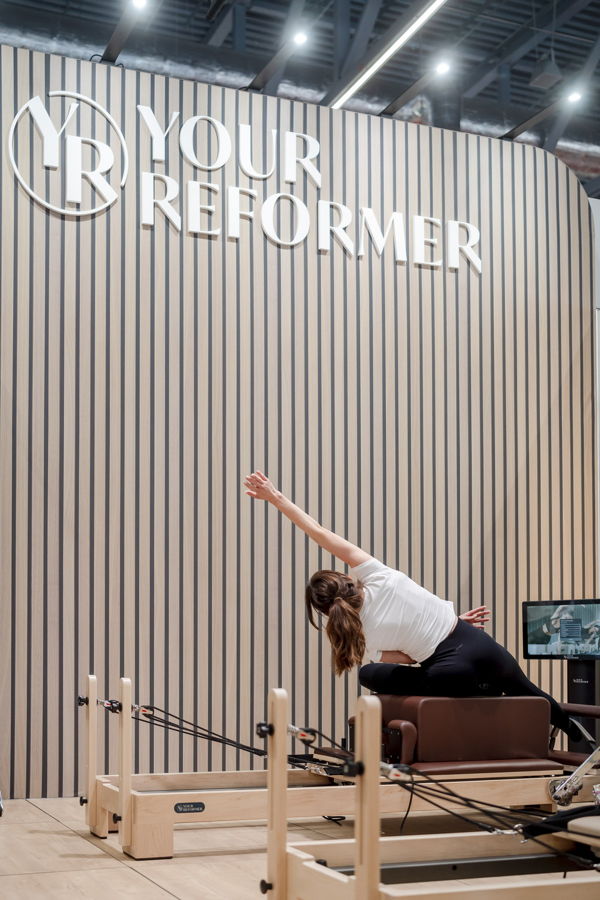 Pilates-Trainingsbereich mit einer Frau auf dem Reformer-Gerät