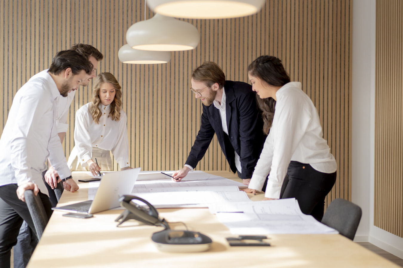 Team bespricht gemeinsam Entwürfe an einem Konferenztisch im Büro