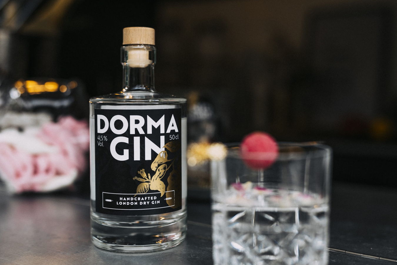 Flasche DORMA GIN neben einem gefüllten Glas auf einem Tisch