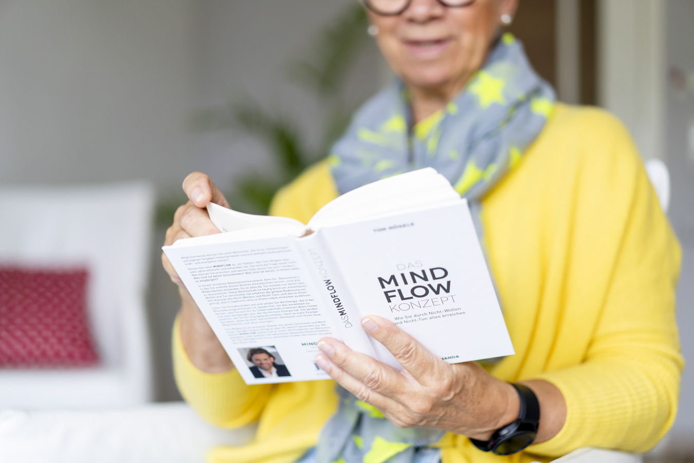 Eine Frau liest ein Buch mit dem Titel „Das Mindflow-Konzept“
