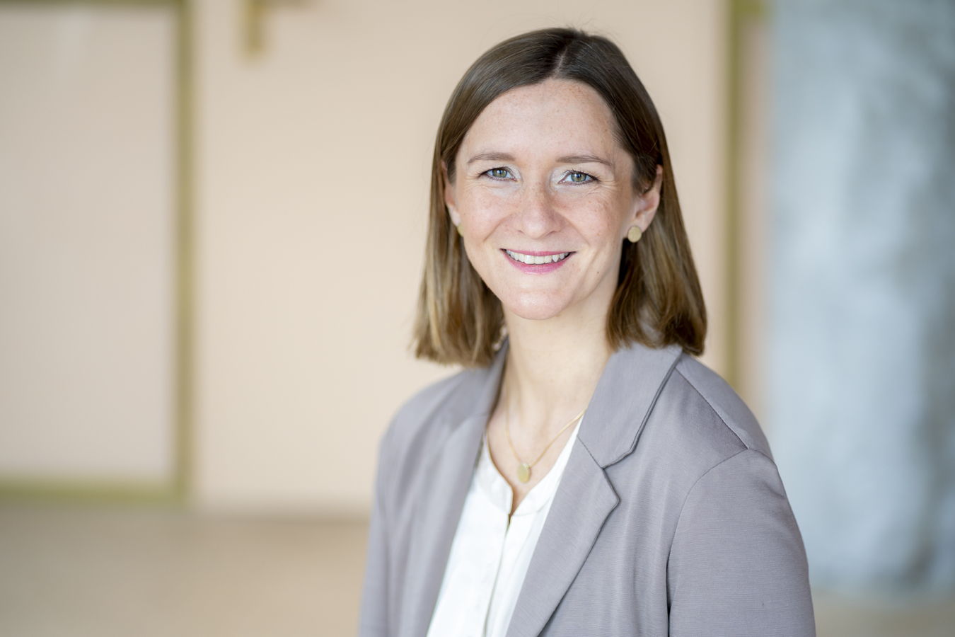 Porträt einer lächelnden Frau im grauen Blazer