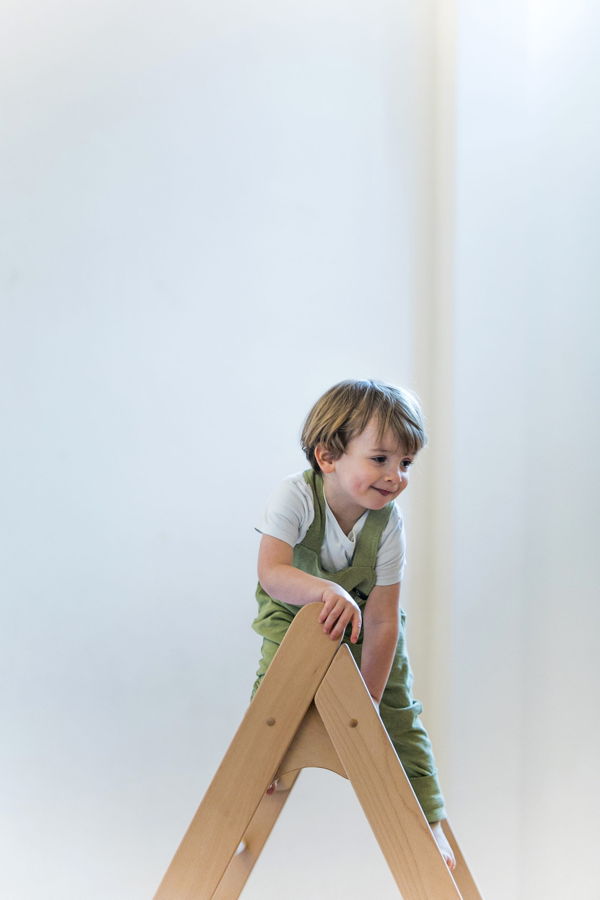 Kleines Kind klettert auf einem Holzspielgerät