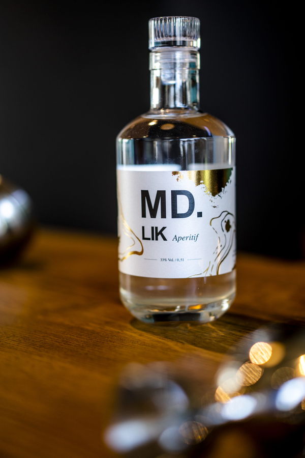 Flasche „MD. LIK Aperitif“ auf einem Holztisch