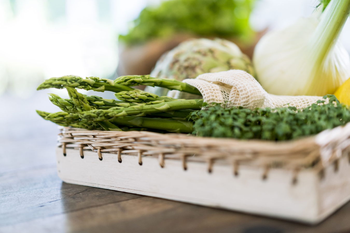 Frisches Gemüse in einem Korb, darunter Spargel, Fenchel und Kräuter