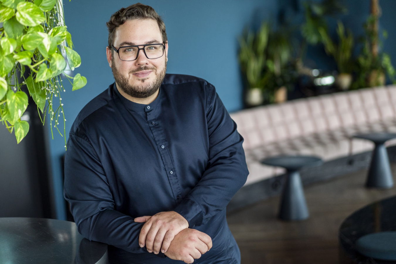 Porträt eines Mannes mit Brille in einem modernen Innenraum