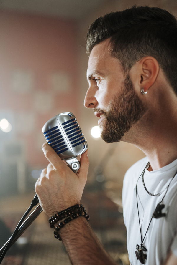 Mann singt in ein Retro-Mikrofon