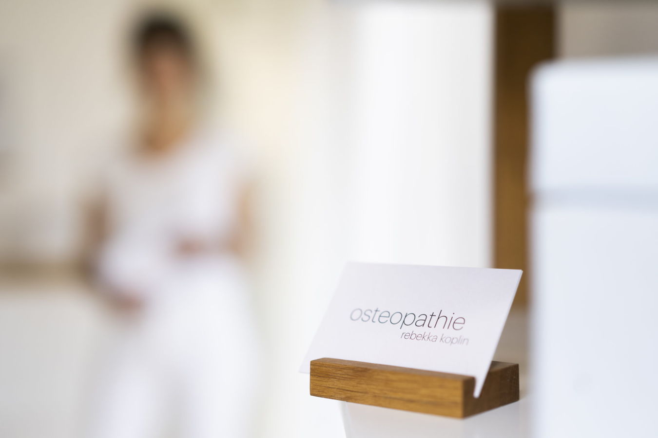 Visitenkarte mit der Aufschrift „osteopathie rebekka koplin“ in einer Praxis