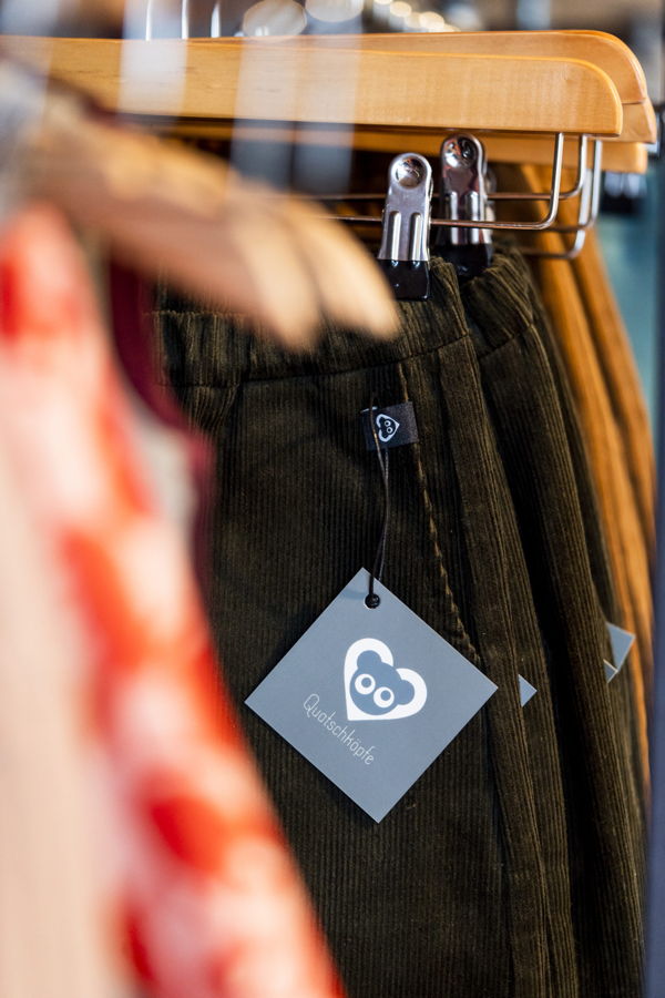 Kleider auf einem Kleiderständer mit Preisschild und Logo von quotschöpfe