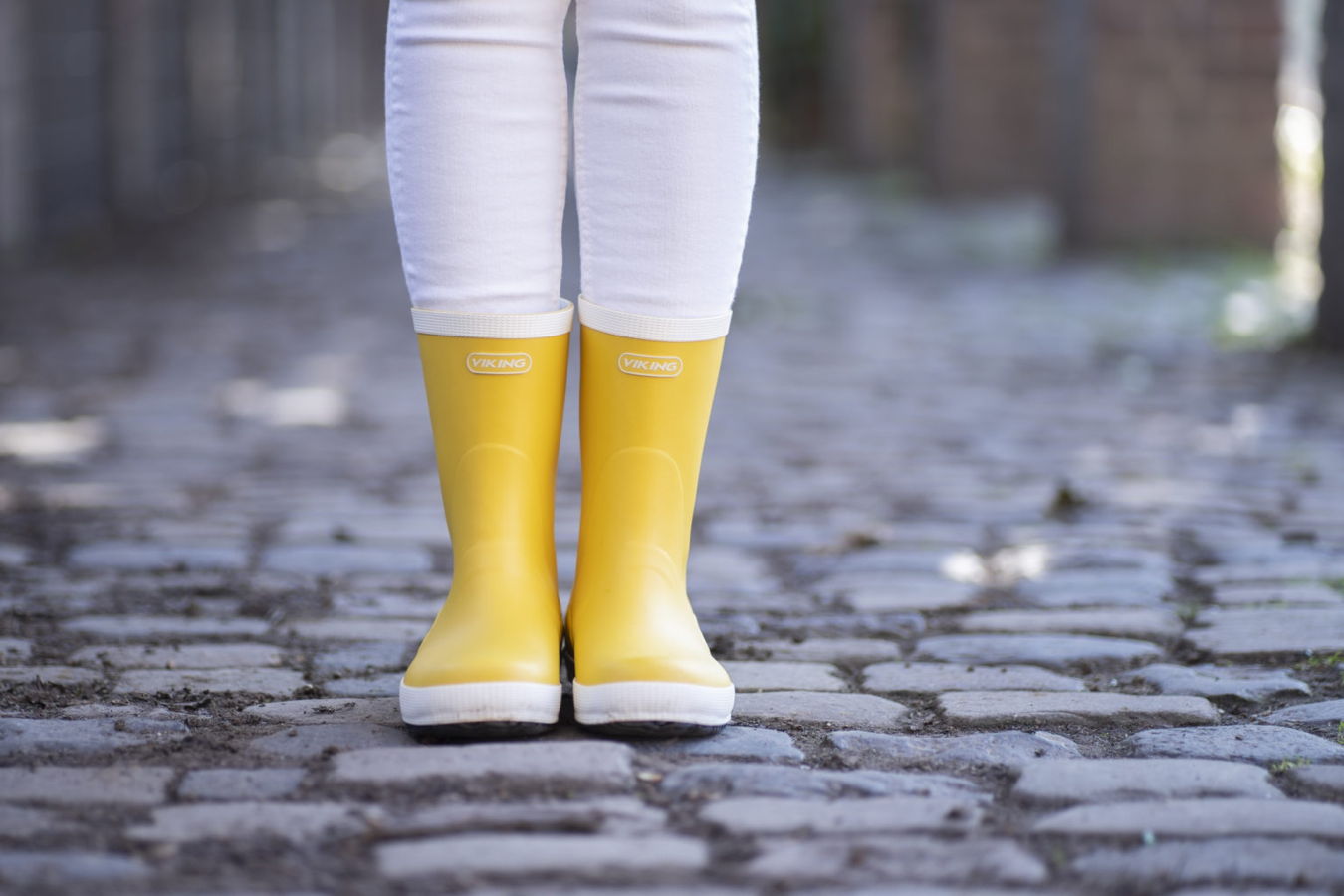 Gelbe Gummistiefel auf Kopfsteinpflaster