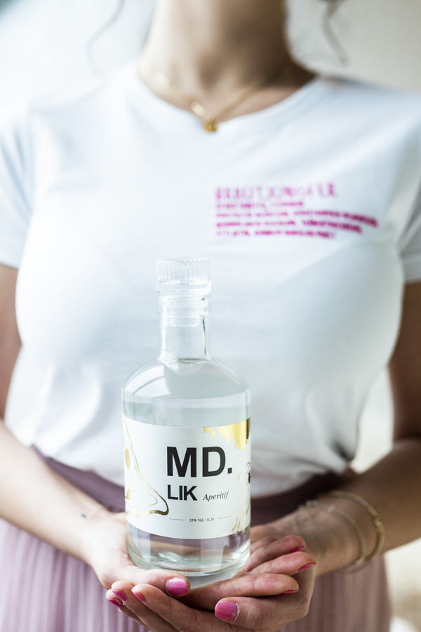 Flasche „MD. LIK Aperitif“ in den Händen einer Person