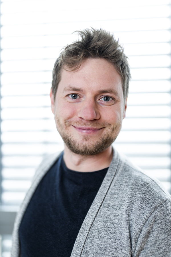 Porträt eines lächelnden Mannes vor hellem Hintergrund