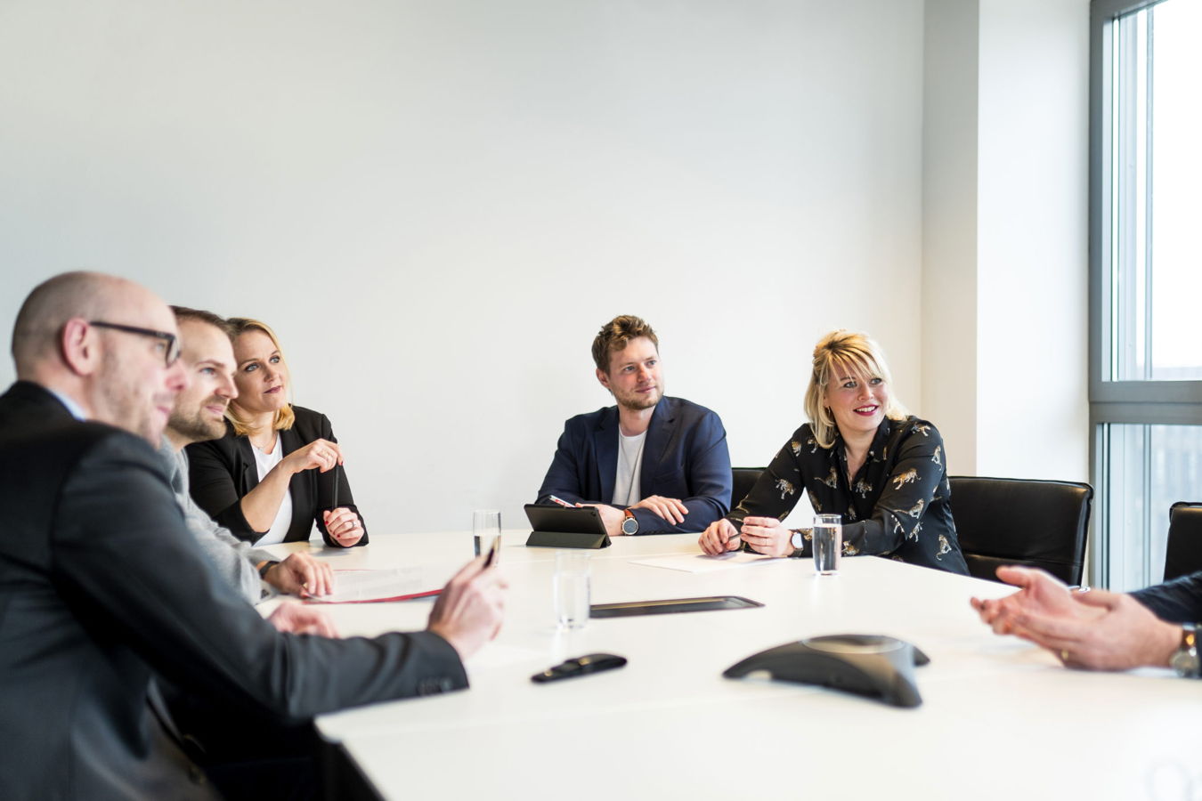 Mehrere Personen sitzen an einem Konferenztisch in einem Besprechungsraum