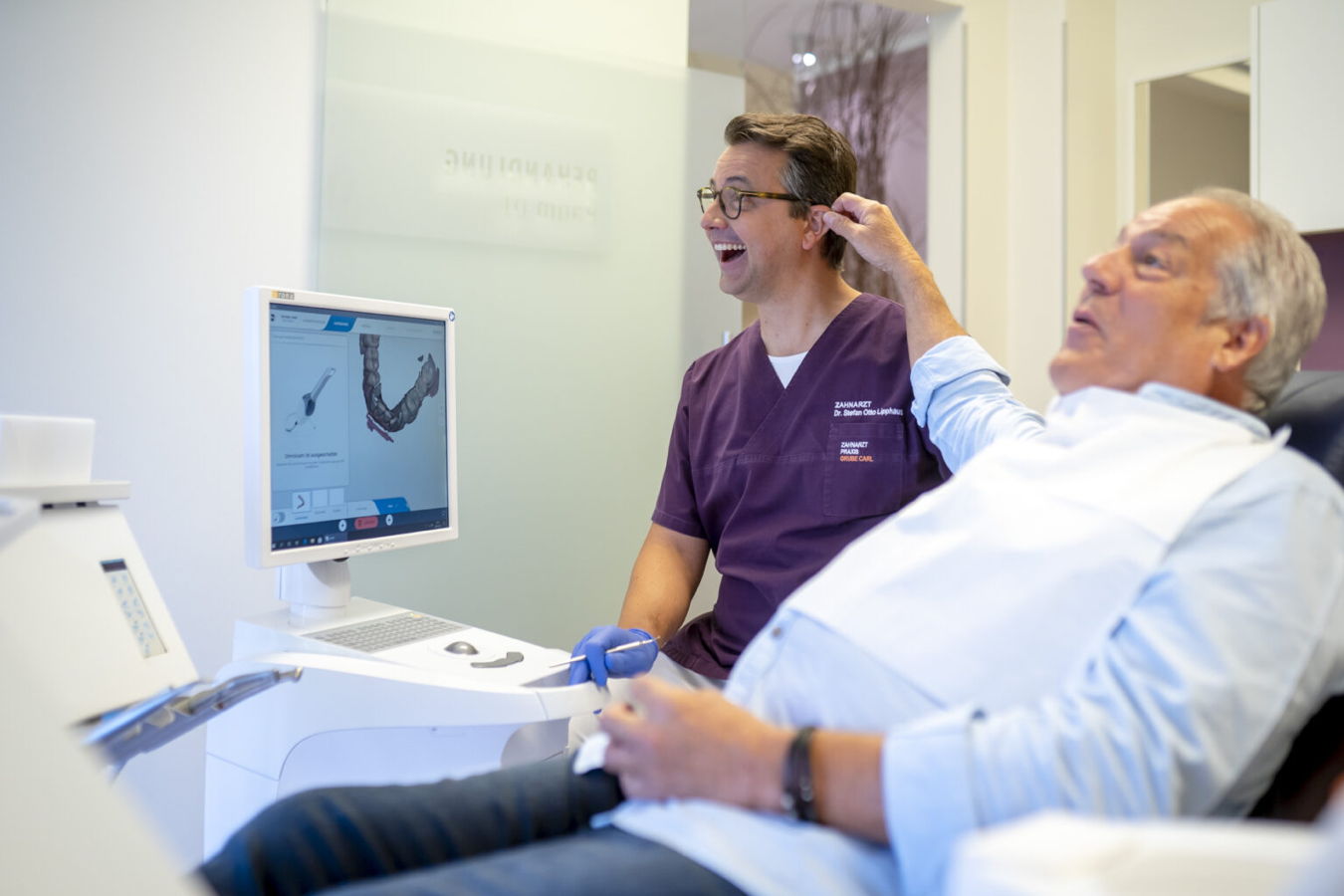 Zahnarzt zeigt einem Patienten eine digitale 3D-Zahnaufnahme auf dem Monitor