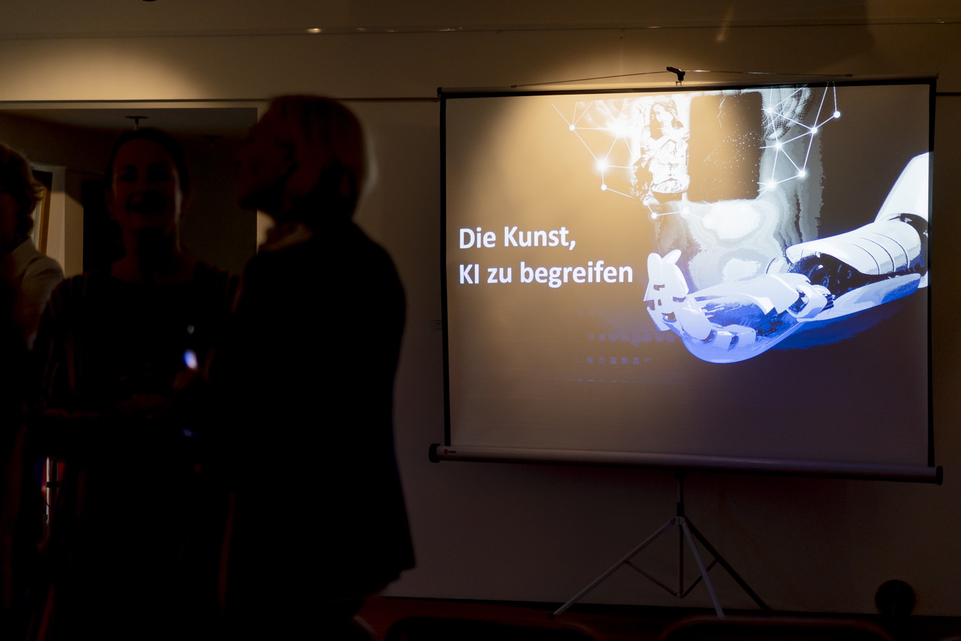 Präsentationsfolie mit dem Text „Die Kunst, KI zu begreifen“ und einer KI-Illustration