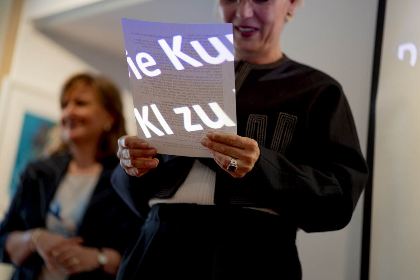 Frau hält ein Blatt mit großem Schriftzug „Kultur“ vor sich