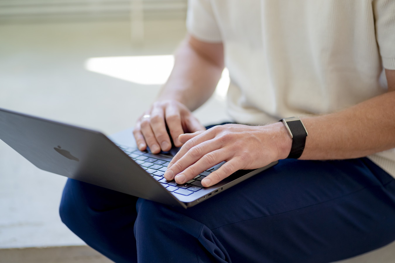 Person tippt auf einem Laptop