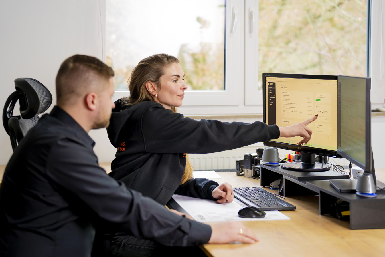 Zwei Personen besprechen etwas am Computerbildschirm im Büro