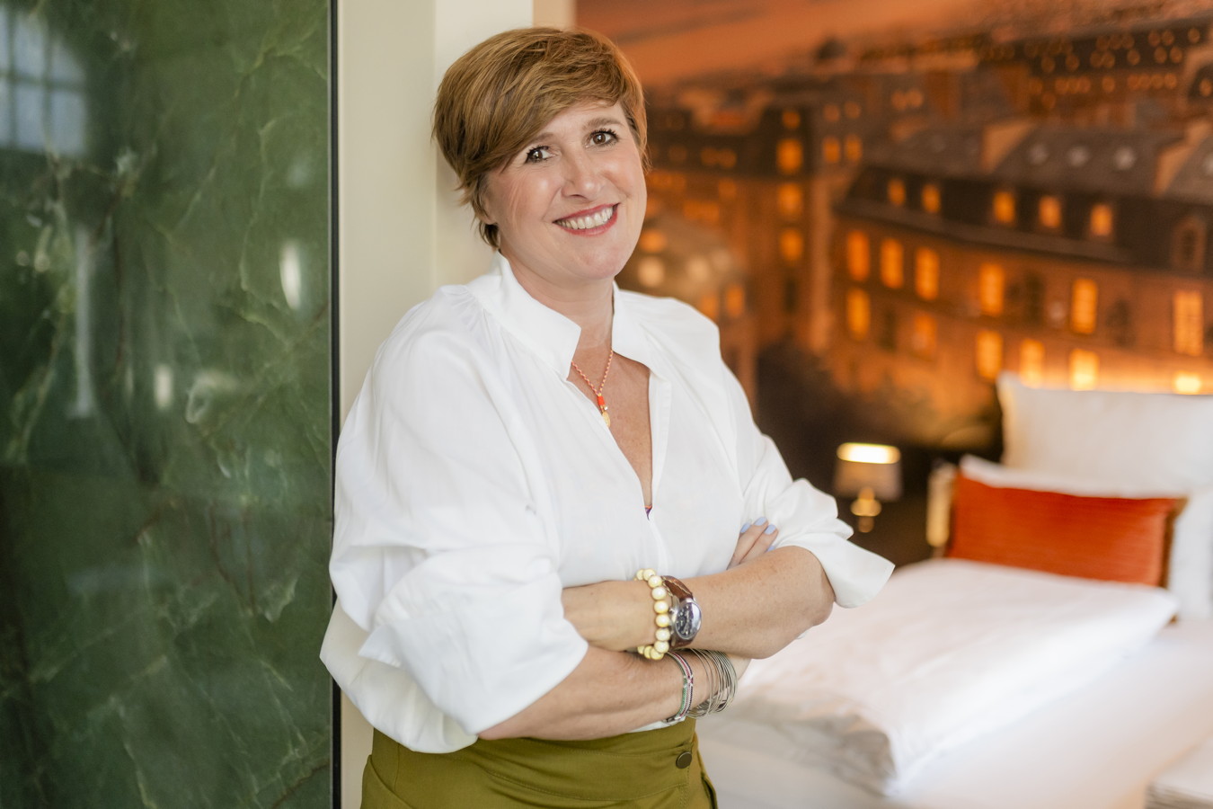 Businessfotos Frau mit verschränkten Armen in einem Hotelzimmer
