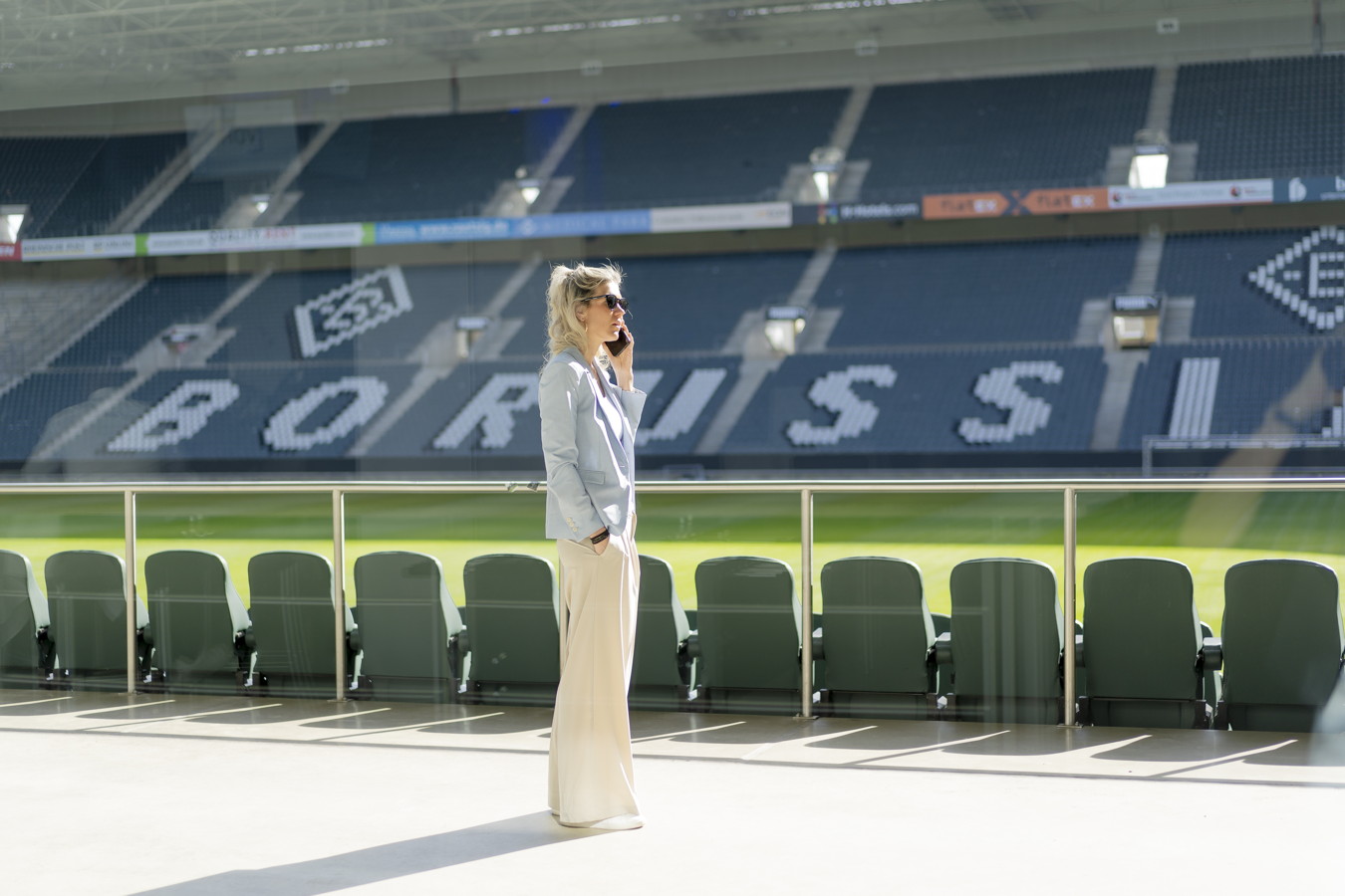 Eine Frau steht mit Handy am Ohr im Borussia-Park-Stadion